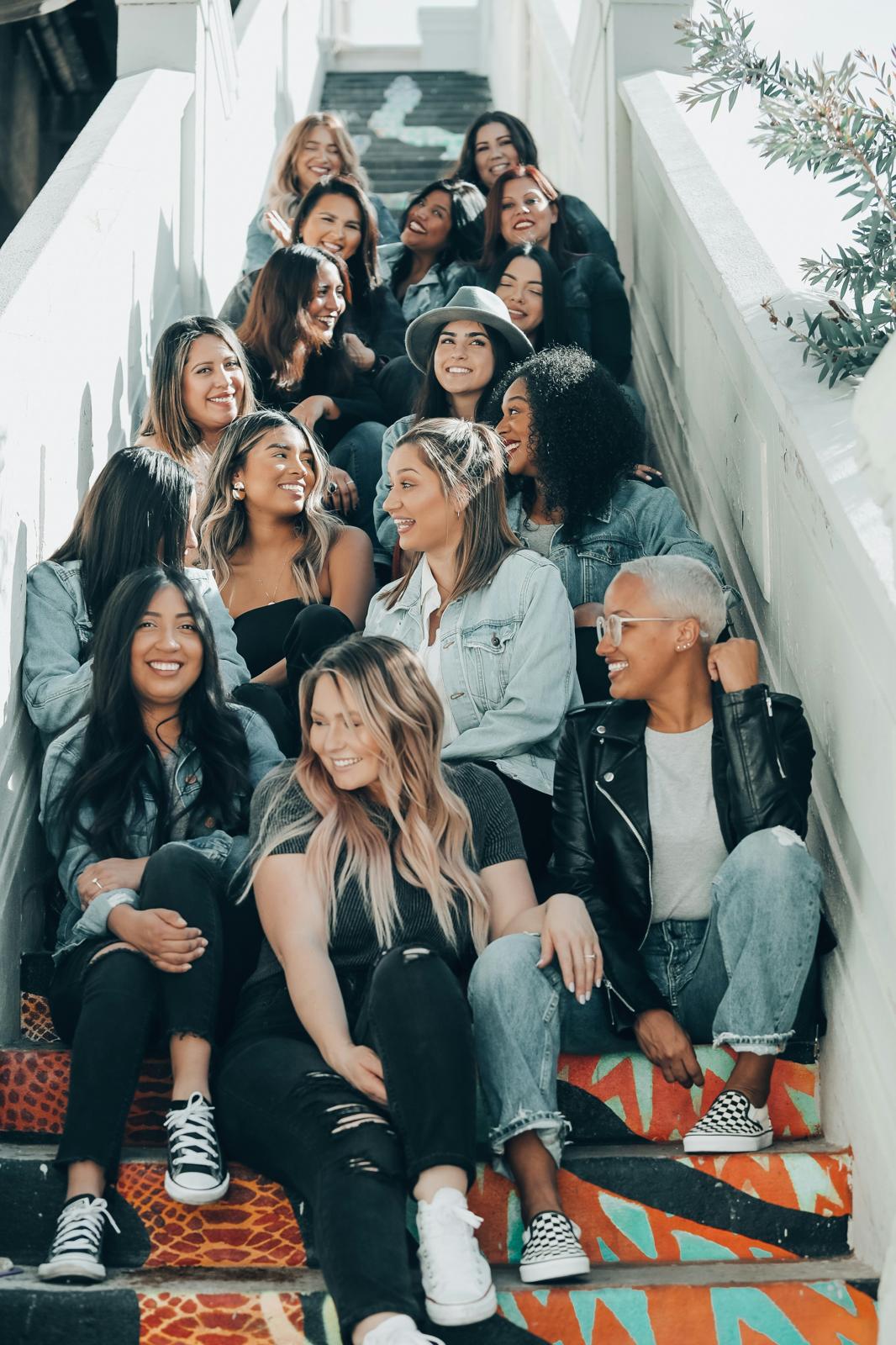 A large group of women sitting together on a staircase