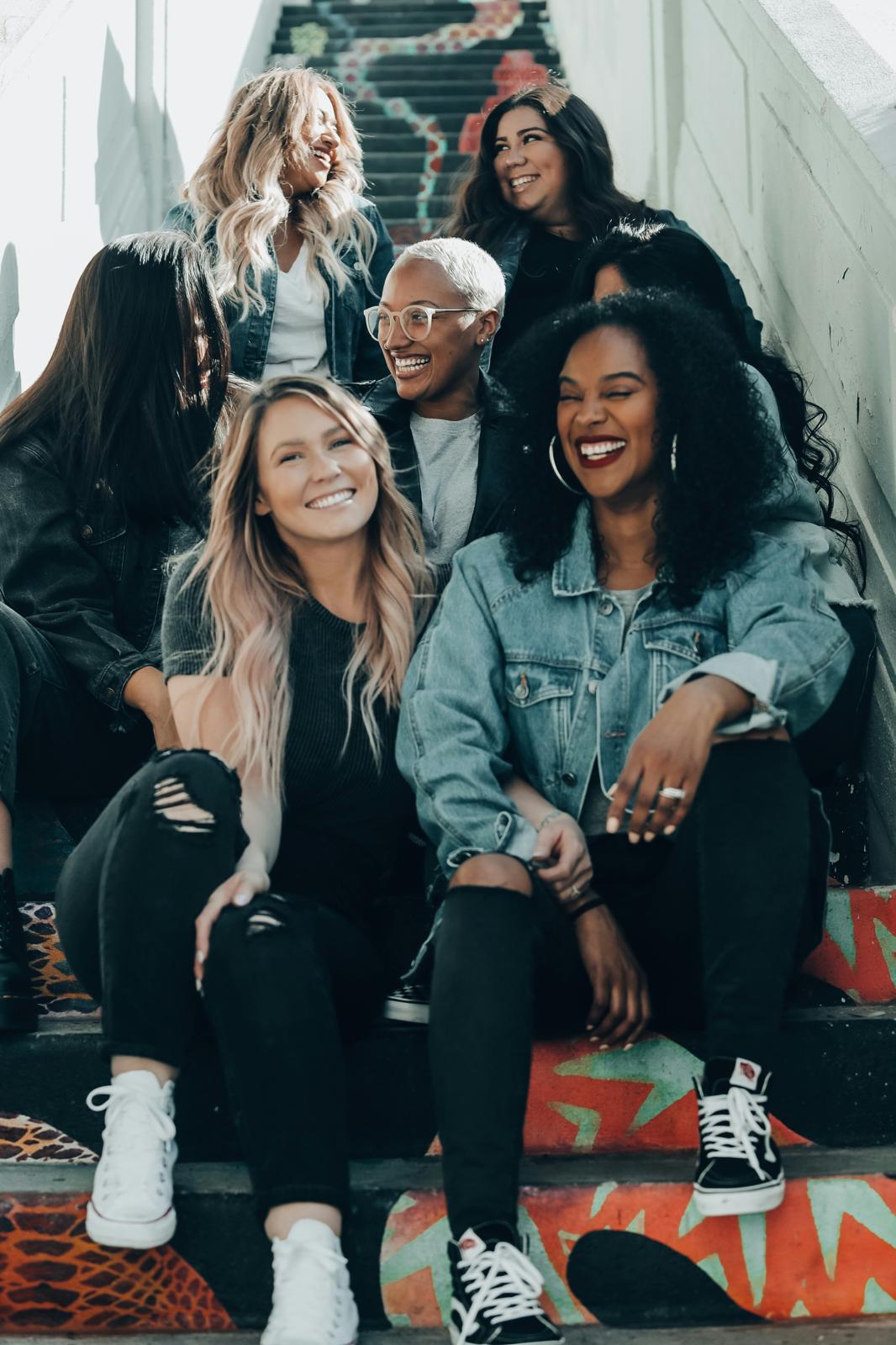 Four friends smiling together on a staircase