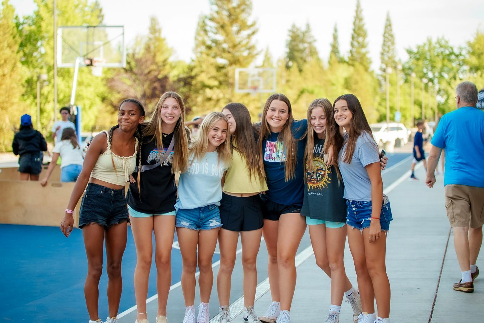 Teenage girls smiling together on a basketball court