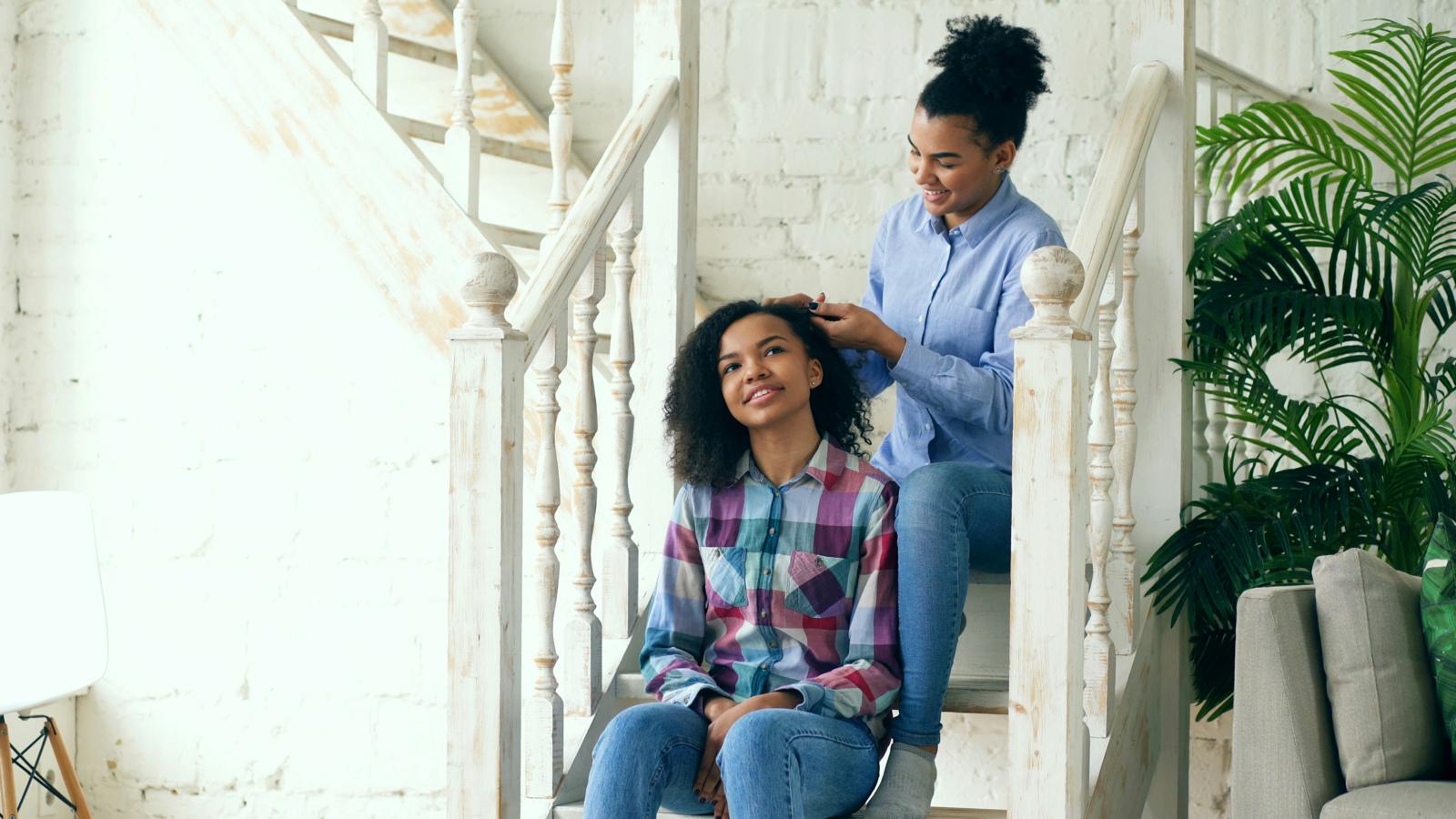 A woman and a teenage girl together on a staircase