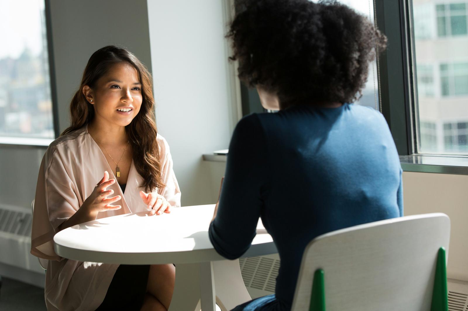 Mentorship Circles: two women in conversation by an office window