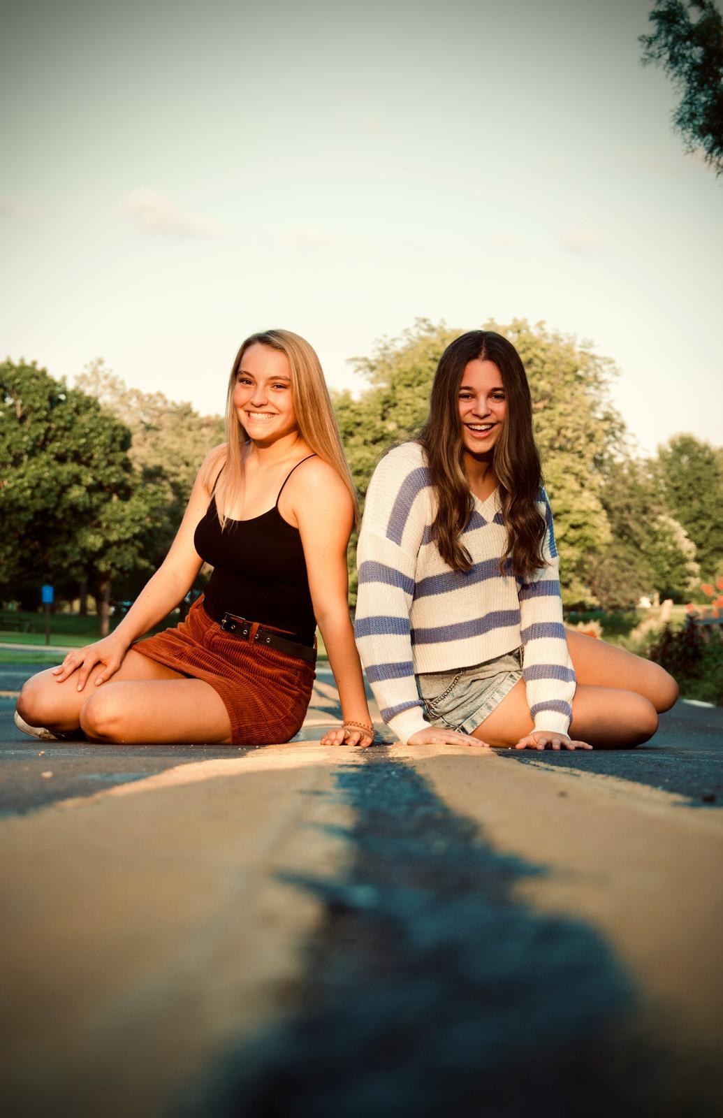 Two young women sitting together in a park