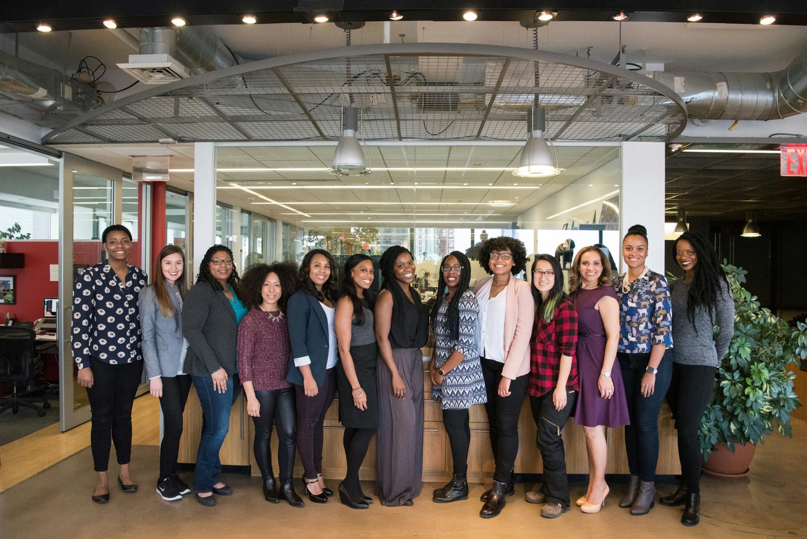 A large group of women posing together in an open-plan office